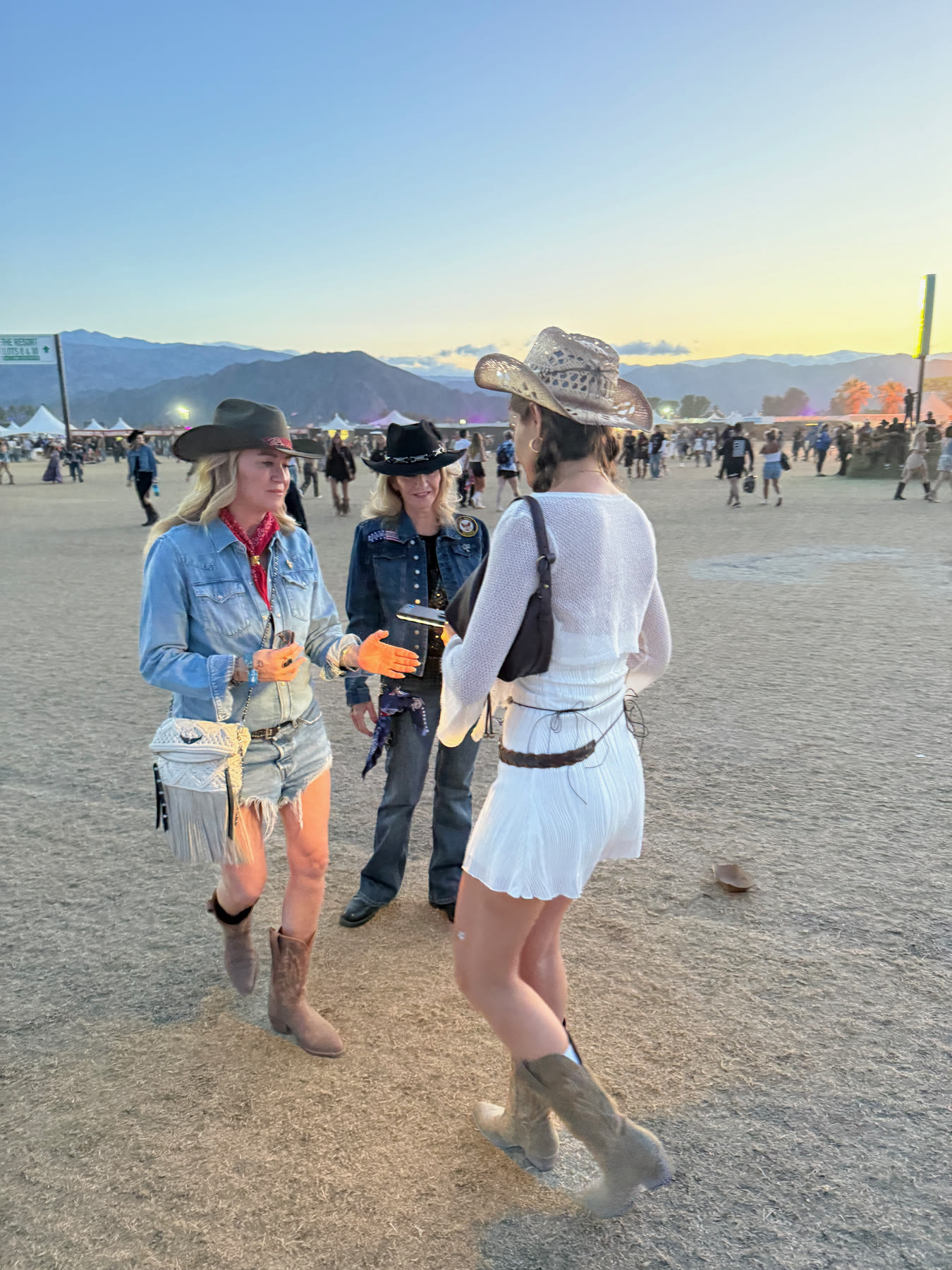 three founding members in hats and boots on the polo field at sunset